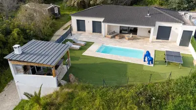 a kitchen with a large island with chairs in it at Villa moderne piscine vue mer in Ajaccio