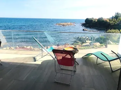 a balcony with a table and chairs and the ocean at Appartement vue mer Piscine Solenzara Résidence Mare Festa B132 in Kamiesch