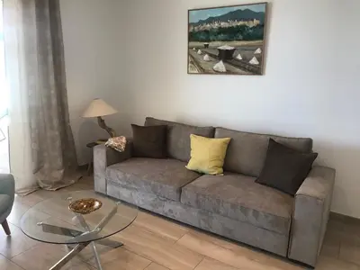 a living room with a couch and a table at Appartement vue mer Piscine Solenzara Résidence Mare Festa B132 in Kamiesch