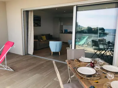 a dining room with a table and a view of the ocean at Appartement vue mer Piscine Solenzara Résidence Mare Festa B132 in Kamiesch