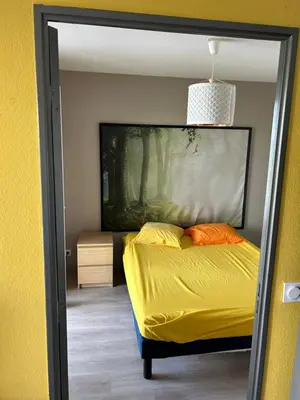 a bedroom with a bed with yellow sheets and orange pillows at Tosca opéra in Ajaccio