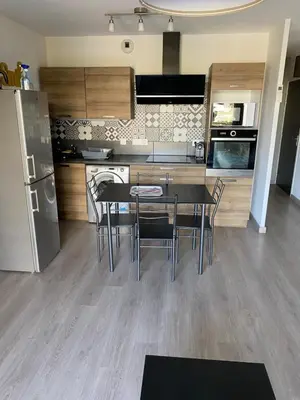 a kitchen with a table and chairs and a refrigerator at Tosca opéra in Ajaccio