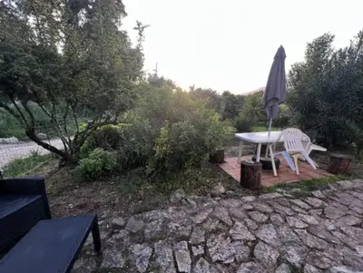 a patio with a table and an umbrella at Chez MANI in Eccica-Suarella