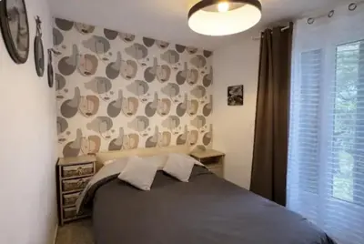 a bedroom with a bed and a large window at Chez MANI in Eccica-Suarella