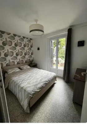 a bedroom with a large bed and a window at Chez MANI in Eccica-Suarella