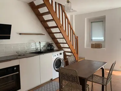a kitchen with a dining table and a staircase at Maison de village typique en Corse mer montagne