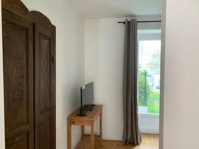 a room with a television on a table next to a window at Maison de village typique en Corse mer montagne