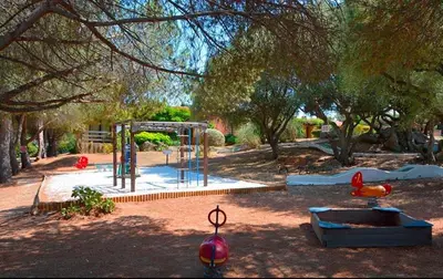 a park with a playground with a swing set at Appartement rénové pour 6 pers tout équipé dans résidence piscine & mer in Serra-di-Ferro