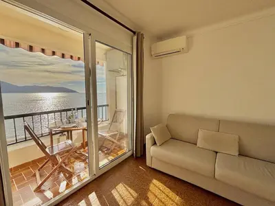 a living room with a couch and a view of the ocean at Studio terrasse vue mer Tiuccia in Calcatoggio