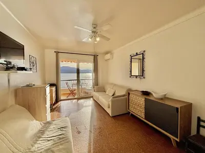 a living room with a couch and a table at Studio terrasse vue mer Tiuccia in Calcatoggio