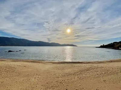 a view of a beach with the sun in the sky at Studio terrasse vue mer Tiuccia in Calcatoggio