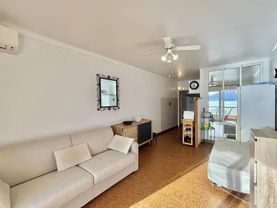 a living room with a couch and a table at Studio terrasse vue mer Tiuccia in Calcatoggio