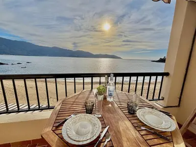 a table on a balcony with a view of the water at Studio terrasse vue mer Tiuccia in Calcatoggio