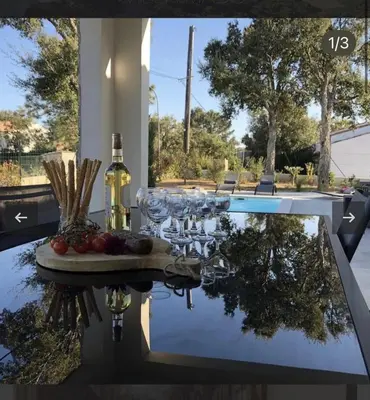 a table with wine glasses and a plate of food on it at Villa Mado 4 Bedrooms, Pool, 6 Personnes, Ste Lucie de Porto Vecchio in Zonza