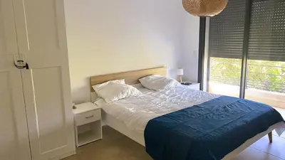 a bedroom with a bed with a blue blanket and a window at Villa Casalonga, 8 pers, piscine chauffée, 1km plage in Cirendinu