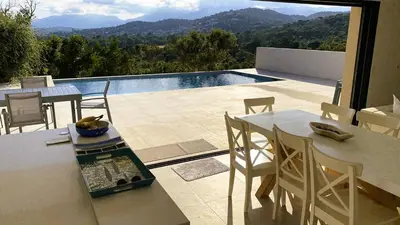 a patio with a table and chairs and a pool at Villa Casalonga, 8 pers, piscine chauffée, 1km plage in Cirendinu