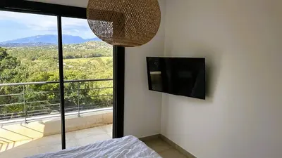 a bedroom with a flat screen tv on the wall at Villa Casalonga, 8 pers, piscine chauffée, 1km plage in Cirendinu