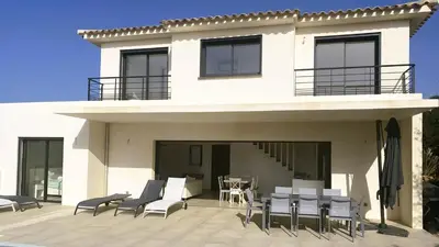 a house with chairs and a table on a patio at Villa Casalonga, 8 pers, piscine chauffée, 1km plage in Cirendinu
