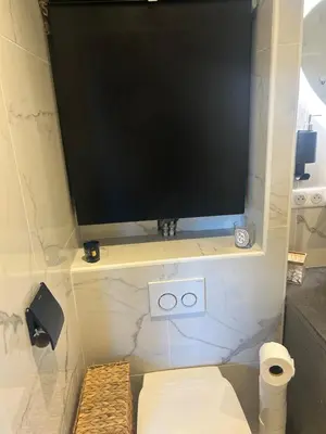a television sitting on a shelf in a bathroom at Villa avec piscine et vue sur la baie d'Ajaccio in Ajaccio