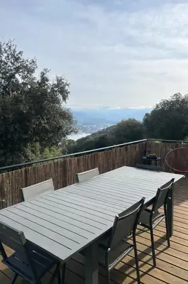 a wooden table and chairs on a wooden deck at Villa avec piscine et vue sur la baie d'Ajaccio in Ajaccio
