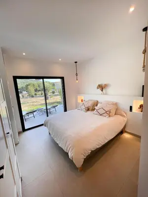 a bedroom with a large bed and a large window at Casa Cagna, 3 bedrooms, Heated pool, 8people in Figari