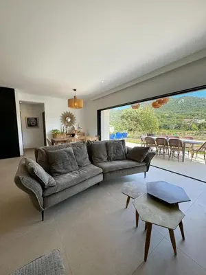 a living room with a couch and a large window at Casa Cagna, 3 bedrooms, Heated pool, 8people in Figari