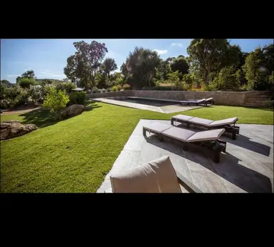 a patio with two chairs and a table in a yard at Villa L'Orangerie, 4 Bedrooms, 8 People, pool, Lecci in Lecci