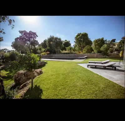 a park with a bench in the grass at Villa l'orangerie, 2 chambres , Piscine, 4personnes in Lecci