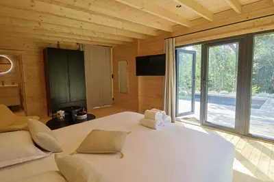 a bedroom with a large white bed and a large window at Chalet Alivi in Porto-Vecchio