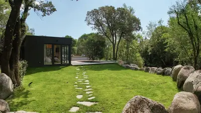 a garden with rocks and a house at Chalet Alivi in Porto-Vecchio