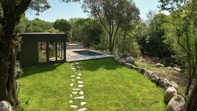 a garden with a house and a swimming pool at Chalet Alivi in Porto-Vecchio