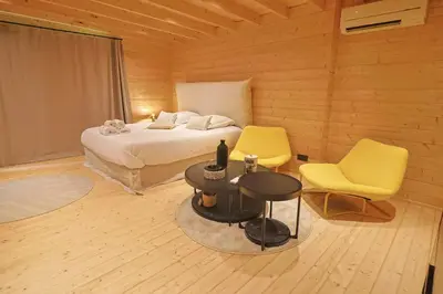 a bedroom with a bed and two yellow chairs at Chalet Alivi in Porto-Vecchio