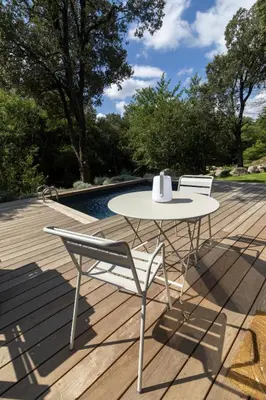 a white table and chairs on a wooden deck at Chalet Alivi in Porto-Vecchio