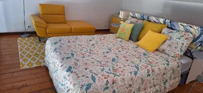 a bedroom with a bed and a yellow chair at Appartement 