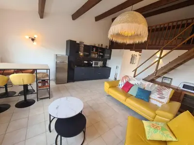 a living room with a yellow couch and a table at Appartement 