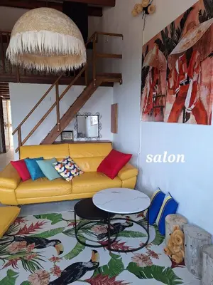 a living room with a yellow couch and a table at Appartement 