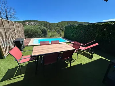 a table and chairs in front of a swimming pool at Villa Corail- Piscine privée- Corsu di Core in Conca