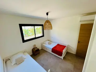 a bedroom with two beds and a window at Villa Corail- Piscine privée- Corsu di Core in Conca