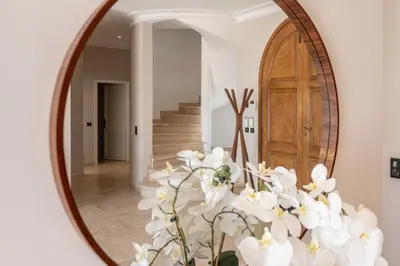 a mirror with a vase of white flowers in a hallway at Château di Cardiccia a Luxury 7-Bedroom Villa with Air Conditioning in Zonza