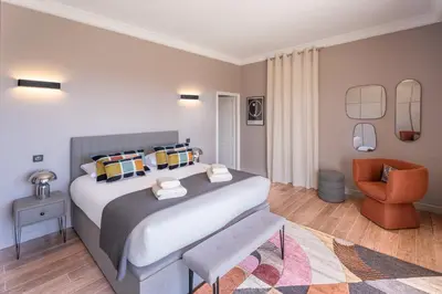 a bedroom with a large bed and a chair at Château di Cardiccia a Luxury 7-Bedroom Villa with Air Conditioning in Zonza