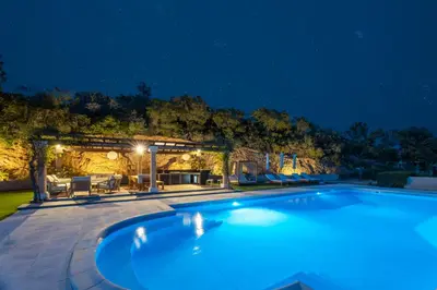 a swimming pool in a backyard at night at Château di Cardiccia a Luxury 7-Bedroom Villa with Air Conditioning in Zonza