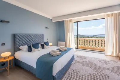a bedroom with a bed and a large window at Château di Cardiccia a Luxury 7-Bedroom Villa with Air Conditioning in Zonza