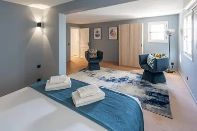 a living room with two chairs and a blue rug at Château di Cardiccia a Luxury 7-Bedroom Villa with Air Conditioning in Zonza