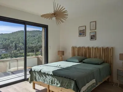 a bedroom with a bed and a large window at Villa Ô Bord de Mer avec piscine privée in Conca