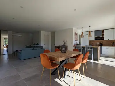 a kitchen and living room with a wooden table and chairs at Villa Ô Bord de Mer avec piscine privée in Conca