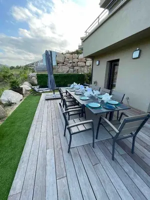 a wooden deck with a table and chairs on it at Villa Ô Bord de Mer avec piscine privée in Conca