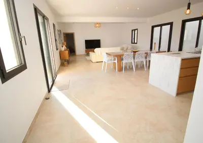 a living room with a kitchen and a table at Villa familiale avec piscine,15 min des plages in Lavatoggio