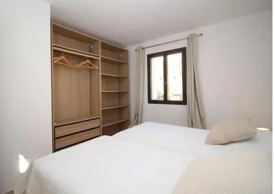 a white bedroom with a bed and a window at Villa familiale avec piscine,15 min des plages in Lavatoggio