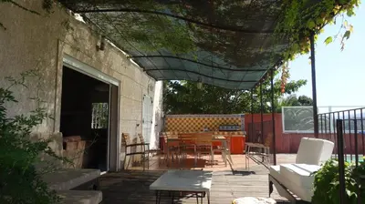 a patio with a table and chairs and a building at E case di u Puntale in Ghisonaccia