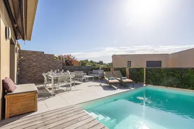 a patio with a table and a swimming pool at Villa Oia - avec piscine privée in Conca